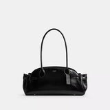 Black handbag with a visible brand tag on a light gray background