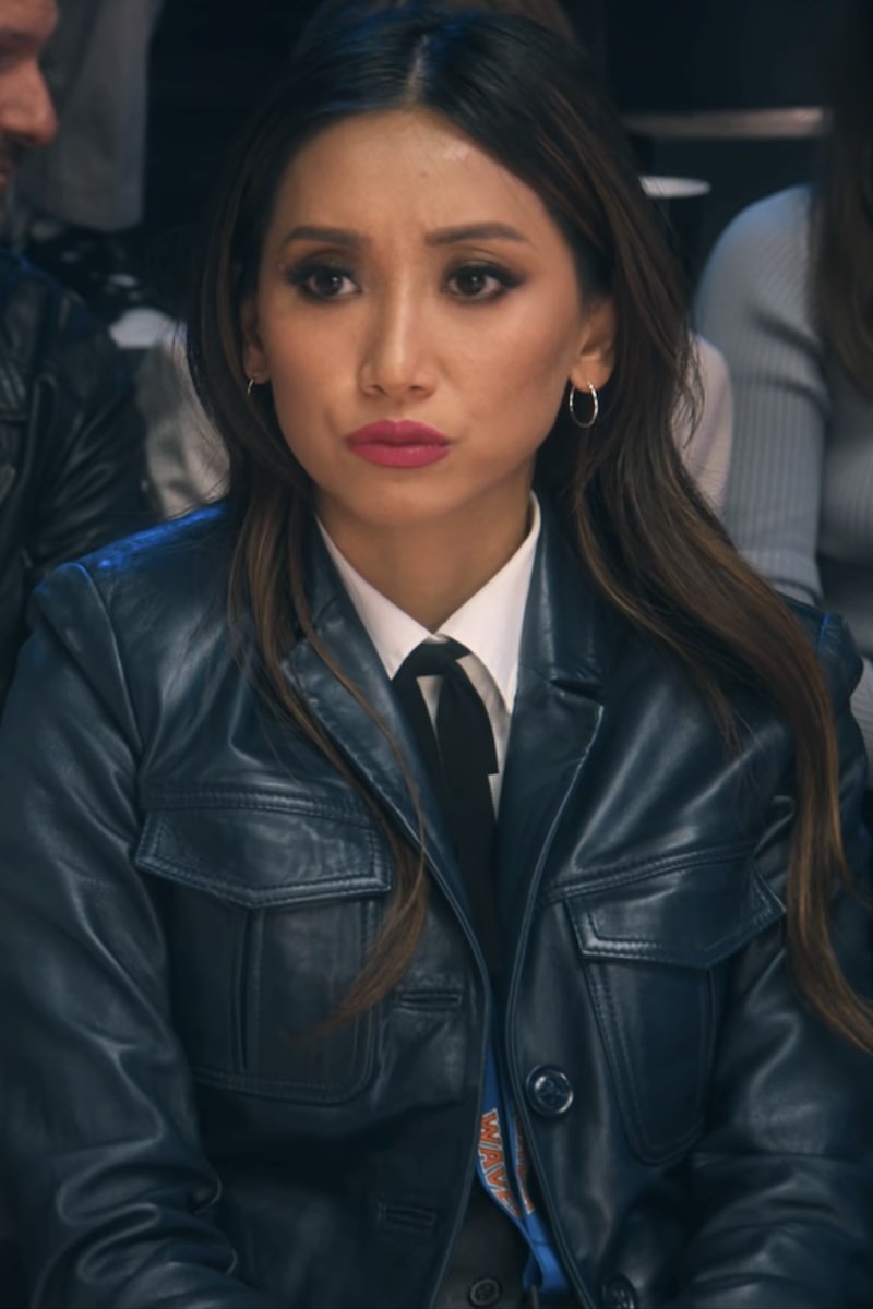 Woman wearing a dark leather jacket with a serious expression