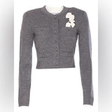 Gray cardigan with a decorative brooch on a white background