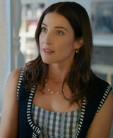 Woman wearing a checkered dress with a black cardigan in an indoor setting