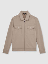 Beige jacket with two front pockets on a light gray background