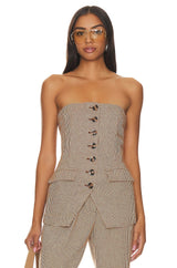 Woman wearing a strapless houndstooth patterned top and pants on a white background