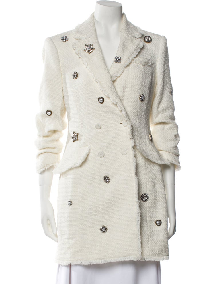 White coat with decorative buttons on a mannequin against a white background
