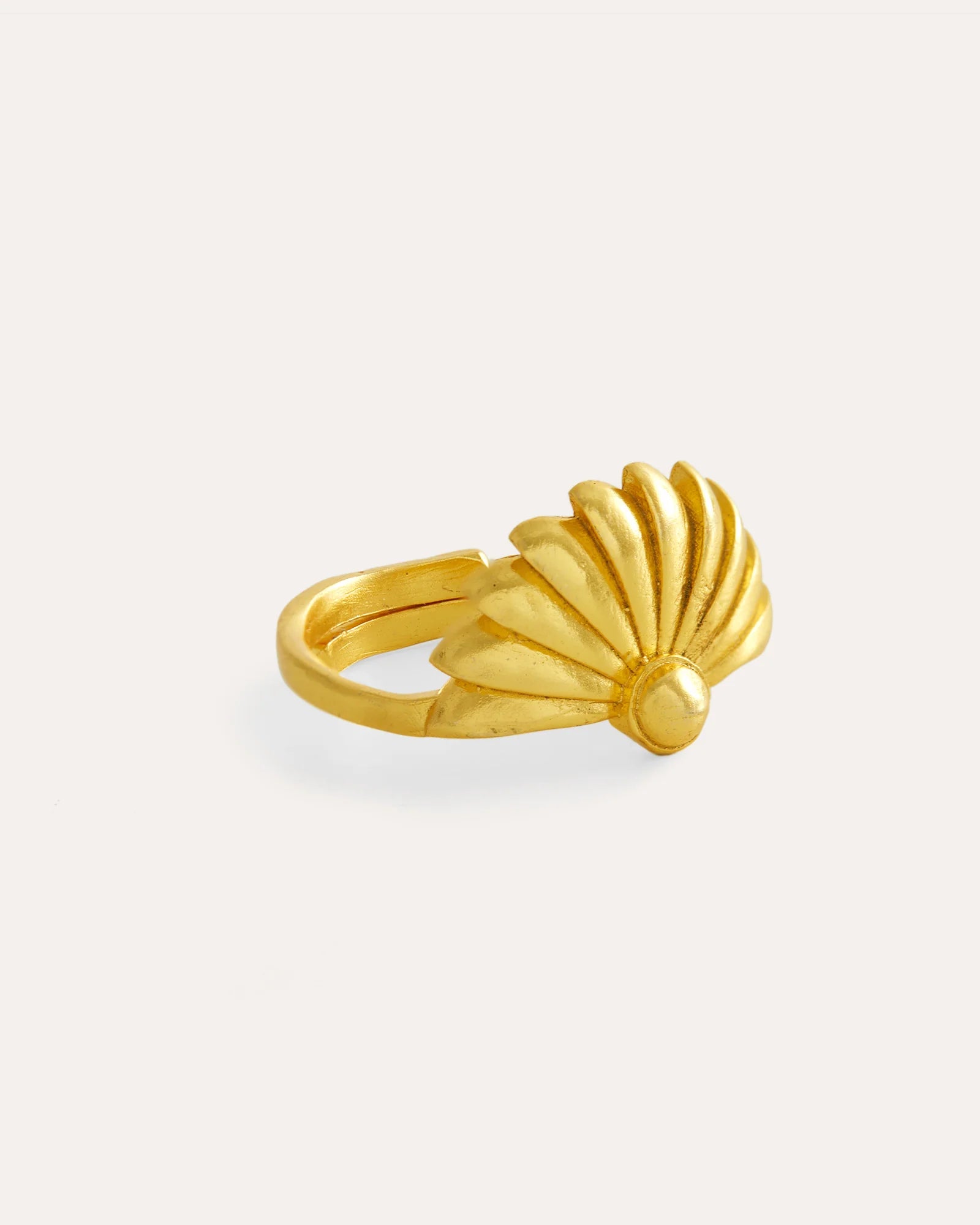Gold shell-shaped ring on a white background