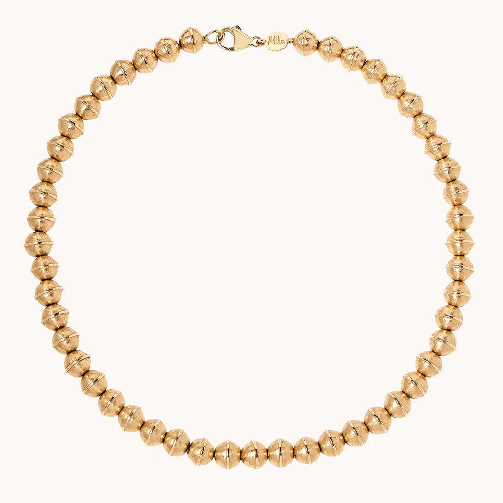 Gold beaded necklace on a white background