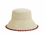 Beige crochet hat with red trim on a white background