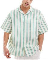 A man wearing a short-sleeve button-up shirt with vertical green and white stripes, styled with white trousers and sunglasses on his head, against a plain white background. The ASOS logo is visible in the top right corner.