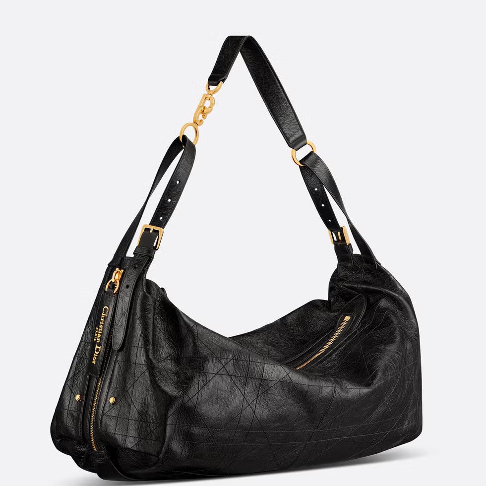 Black leather handbag with gold accents on a light gray background