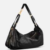 Black leather handbag with gold accents on a light gray background