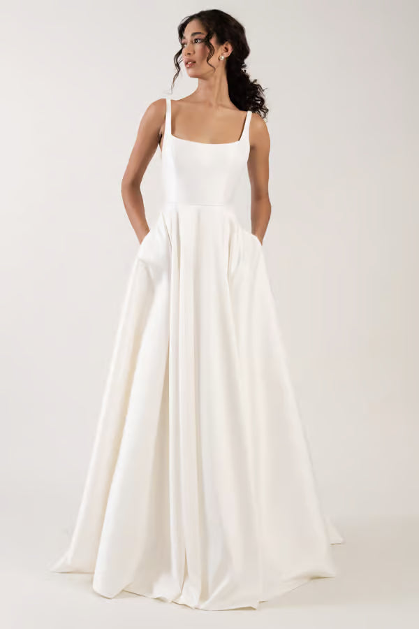 Woman wearing a white dress against a plain background