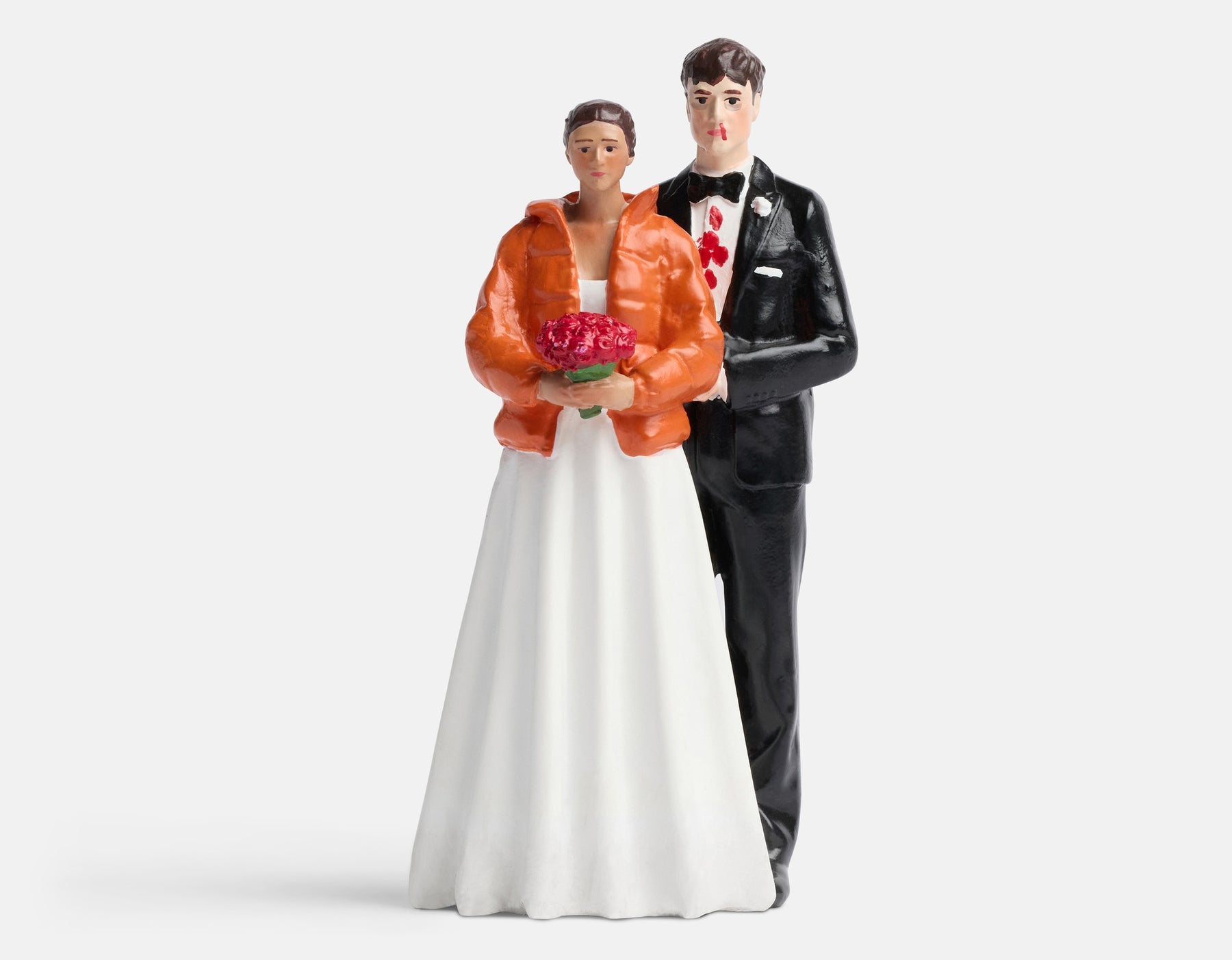 Wedding cake topper figurines of a couple on a white background