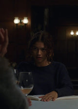 Two people sitting at a table in a dimly lit room with wine glasses.